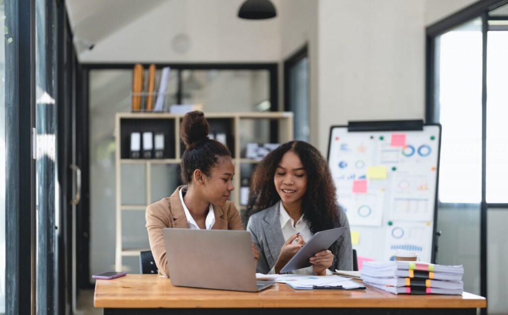 two young business people working together in office financial analysis accounting concept